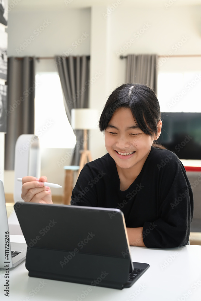 Portrait of young Asian girl video conference with teacher on tablet computer at home. Online education concept. Portrait of young Asian girl video conference with teacher on tablet computer at home. Online education concept.