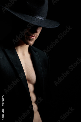 sexy young man in jacket wearing hat posing in a fashion light © Viorel Sima