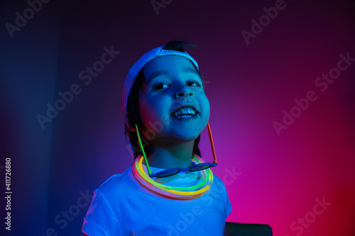 cyberpunk boy child in a white T shirt and large headphones listening to music on the background of the wall