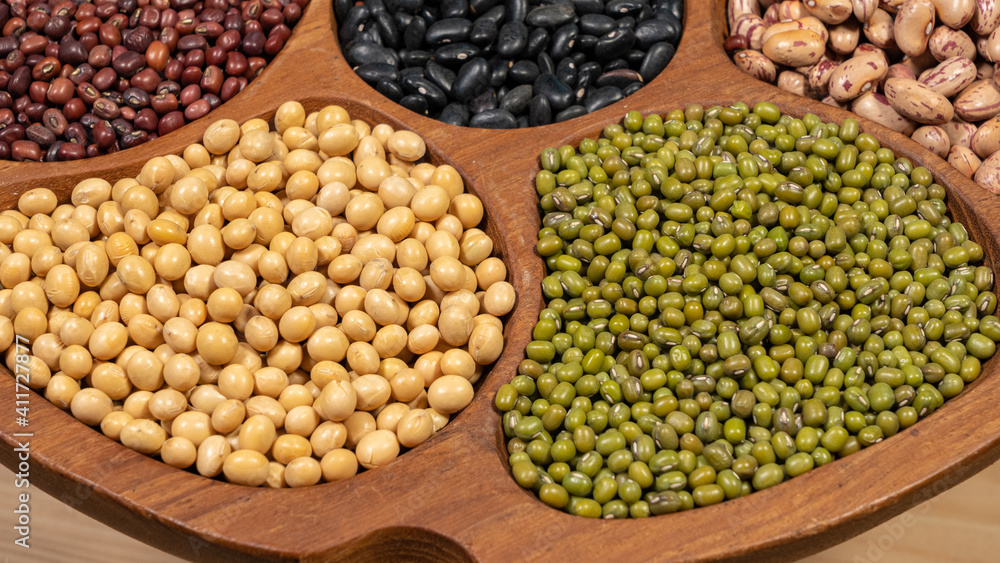 Closeup of soybeans and mung beans in wooden container, top view, healthy eating concept Closeup of soybeans and mung beans in wooden container, top view, healthy eating concept