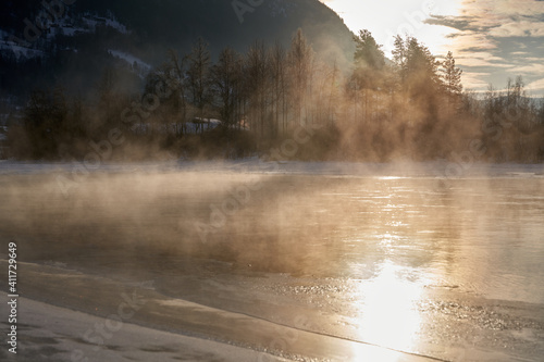 The river is about to freeze. It is very cold and the river is much warmer than the air, therefore the smoke or the damp from the river. Shot at Gol, Norway in February. Minus 20 degreases Celsius.  © SteinOve