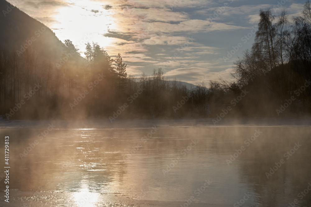 The river is about to freeze. It is very cold and the river is much warmer than the air, therefore the smoke or the damp from the river. Shot at Gol, Norway in February. Minus 20 degreases Celsius. The river is about to freeze. It is very cold and the river is much warmer than the air, therefore the smoke or the damp from the river. Shot at Gol, Norway in February. Minus 20 degreases Celsius.