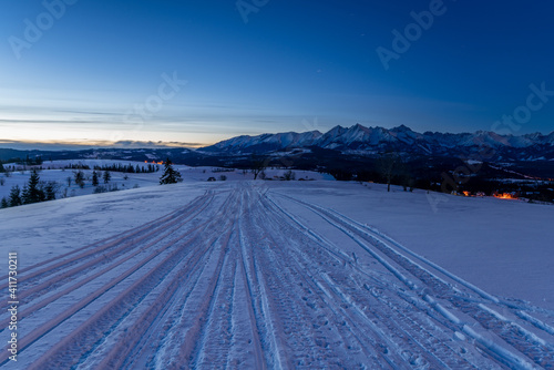 traces in the snow of driving snowmobiles in a beautiful mountain scenery © Mike Mareen