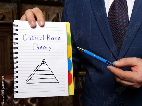 Financial concept about Critical Race Theory with sign on the white notepad. photo