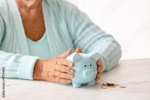 Senior woman with piggy ban...