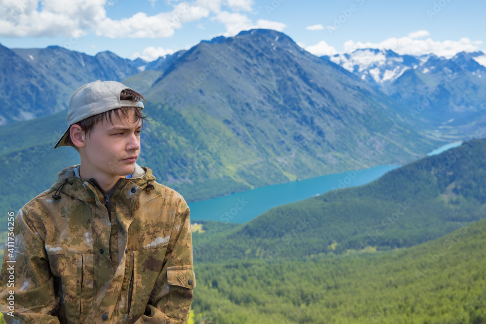Portrait of a teenage boy on a background of mountains.