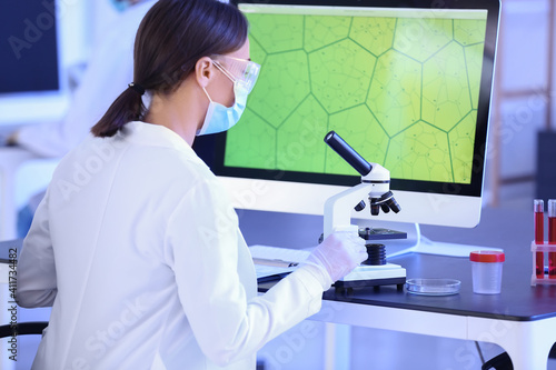 Scientist studying sample in laboratory