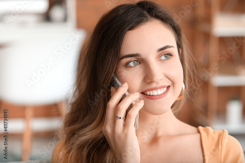 Young woman talking by mobi...