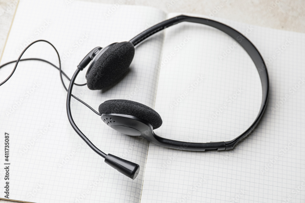 Headset with notebook on table Headset with notebook on table