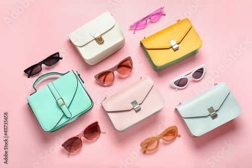 Composition with sunglasses and bags on color background photo