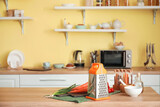 Grater and vegetables in modern kitchen