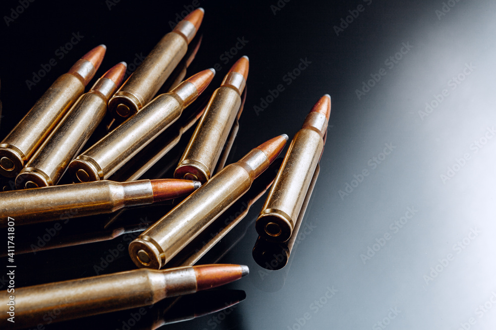Rifle bullets or cartridges on black shiny background Rifle bullets or cartridges on black shiny background