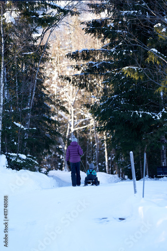 Family of mother, son and daughter walking in the winter forest. 