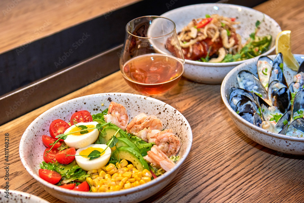 Delicious shrimp salad in restaurant on a wooden table. Tasty seafood with beer in cafe or pub menu.