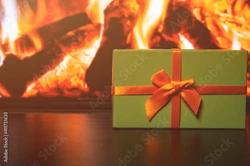 Gift box and nearby cones on the background of a home fireplace. photo