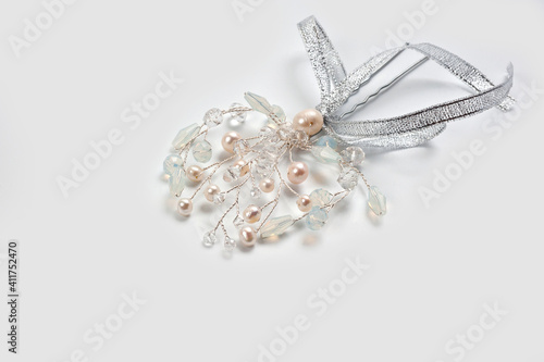 A hair clip on a hairpin in the form of a twig made of silver wire, decorated with river pearls and crystal.