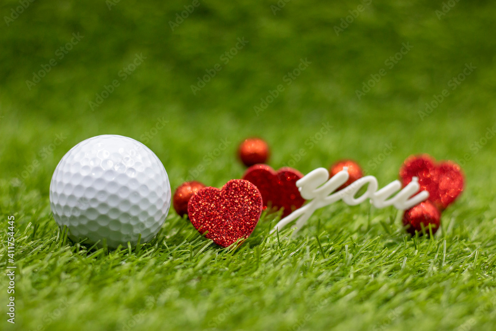 Naklejka premium Golf ball and love is on green grass
