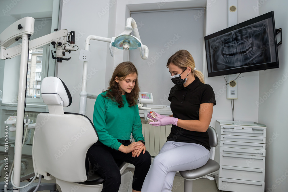 dentist shows artificial jaw and telling about to properly care for the oral cavity dentist shows artificial jaw and telling about to properly care for the oral cavity
