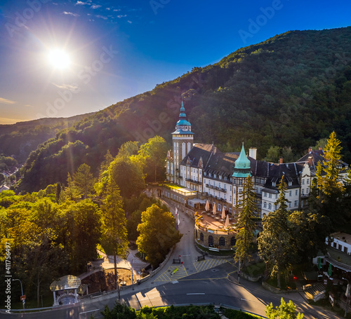 Lillafured, Hungary - Aerial view of the famous Lillafured Castle in the mountains of Bukk near Miskolc on a sunny summer morning. Rising sun with sunrays and clear blue sky photo