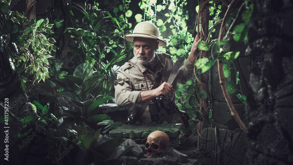 Brave explorer walking in the jungle with a machete
