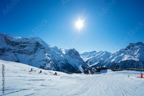 Mountain peaks and clean empty ski trails in Pralognan-la-Vanoise range over snowy tops in French Alps photo