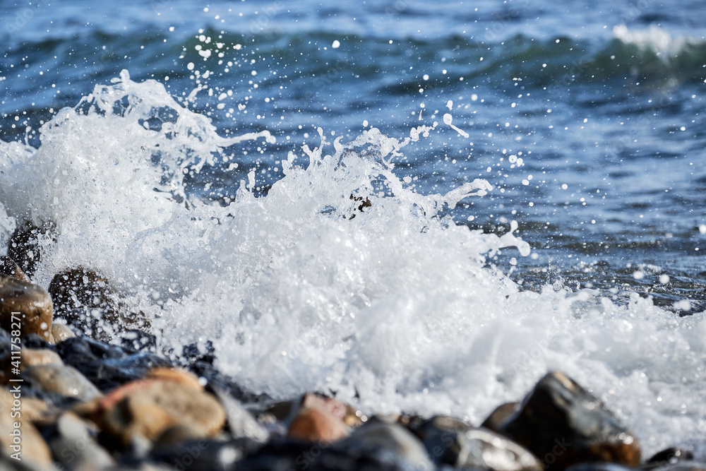 Sea waves break on shingle beach. Small wave rolls onto shore and splash of foam flies in different directions. Beautiful marine minimalist screensaver. Sea waves break on shingle beach. Small wave rolls onto shore and splash of foam flies in different directions. Beautiful marine minimalist screensaver.