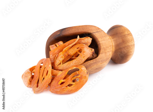 Mace in a wooden scoop, isolated on white background. Nutmeg flower, myristica fragrans. Natural spice, asian seasoning. photo