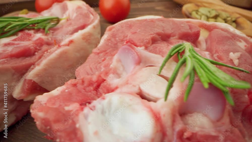 Fresh raw meat steaks on wooden board with spices close up Fresh raw meat steaks on wooden board with spices close up