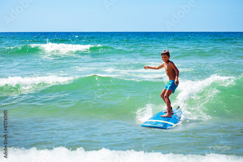 Photography Young 10 years old boy action photo ride surfboard on a wave in the sea