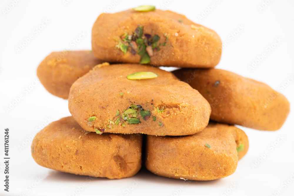 Indian Mithai Brown Mathura Peda Or Meetha Pera Made Of Condensed Milk Fudge Khoya Mawa Kesar Khoa Pista Mava Malai In Pure Desi Ghee Stacked In Plate. White Background With Copy Space For Text