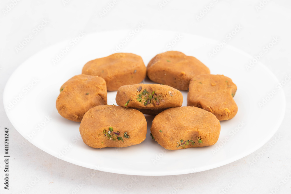 Indian Mithai Brown Mathura Peda Or Meetha Pera Made Of Condensed Milk Fudge Khoya Mawa Kesar Khoa Pista Mava Malai In Pure Desi Ghee Served In Plate. White Background With Copy Space For Text