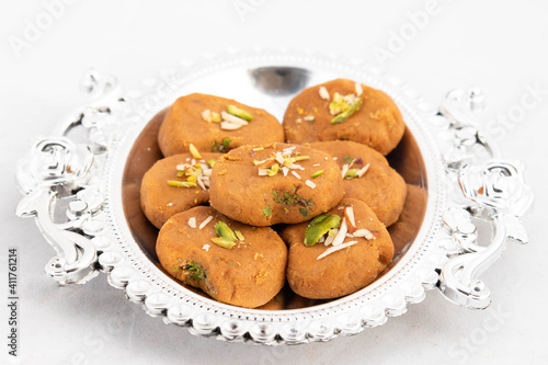 Indian Mithai Brown Mathura Peda Or Meetha Pera Made Of Condensed Milk Fudge Khoya Mawa Kesar Khoa Pista Mava Malai In Pure Desi Ghee In Decorative Silver Tray. White Background With Space For Text