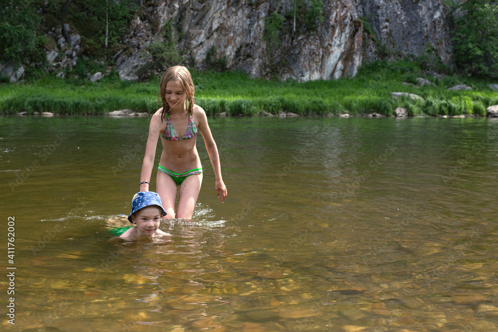 Older sister helps little brother learn to swim Older sister helps little brother learn to swim