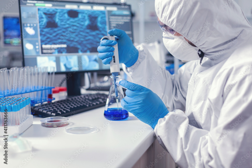 Man in scientific lab working with micropipette and petri dish during