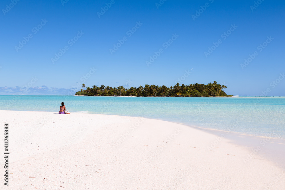 Woman sitting on a beach, Aitutaki, Cook Islands Woman sitting on a beach, Aitutaki, Cook Islands