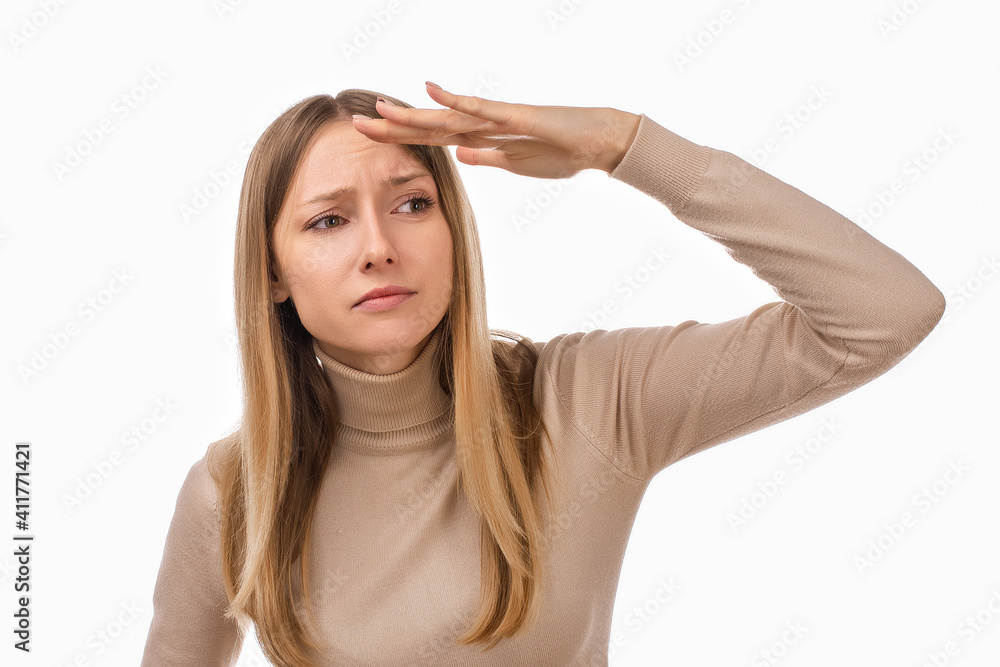 Portrait of a curious blond girl looking far away with hand at her forehead, trying to see something far away Portrait of a curious blond girl looking far away with hand at her forehead, trying to see something far away