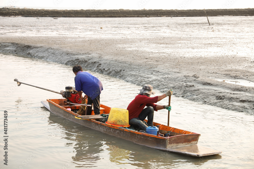 Naklejka premium Two workers helped to row the boat ashore.