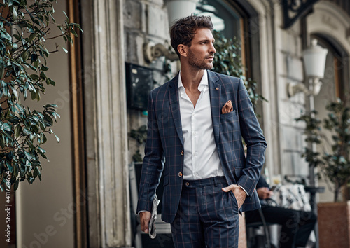 Handsome male model in checked suit walking on the street photo