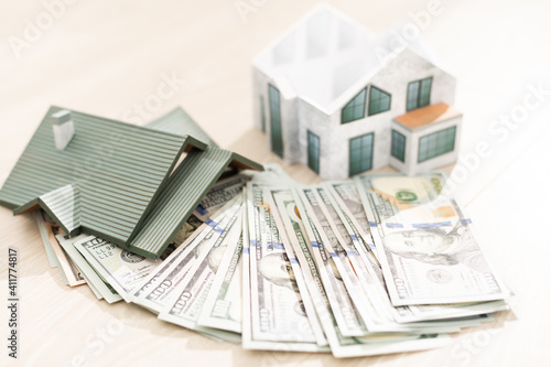 The model of the house costs on a pile of notes. Purchase and sale
