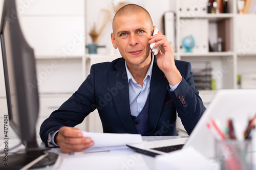 Man office worker deciding and talking on the phone