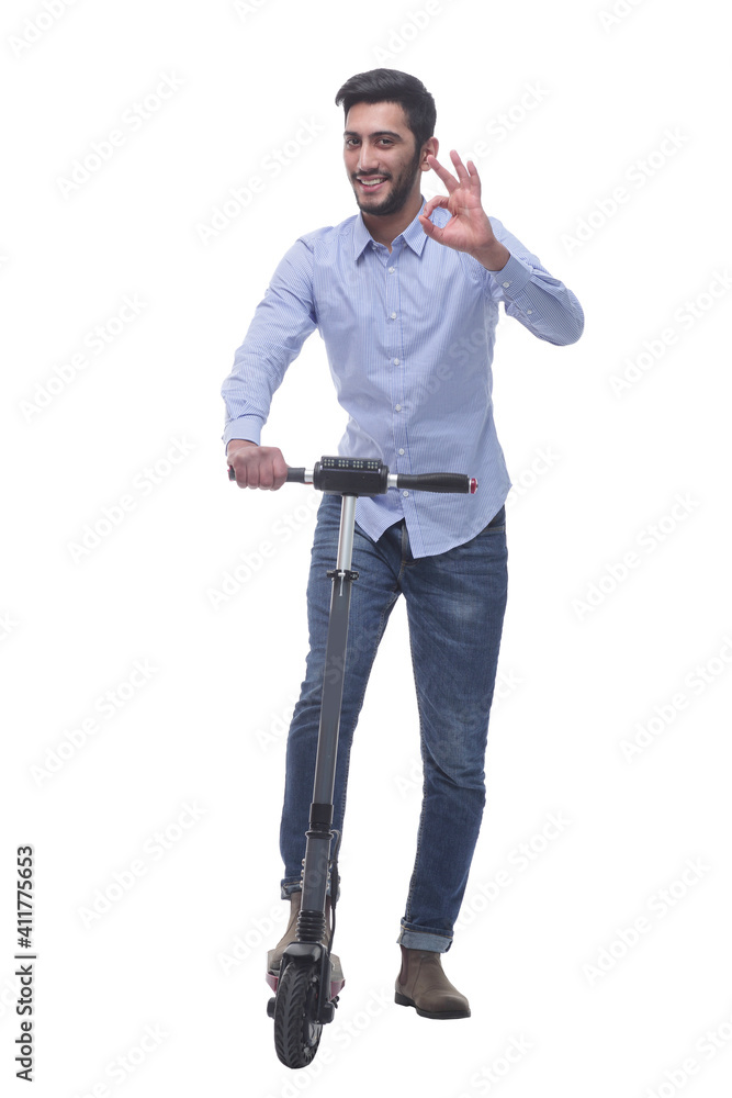 in full growth. happy young man with an electric scooter in full growth. happy young man with an electric scooter