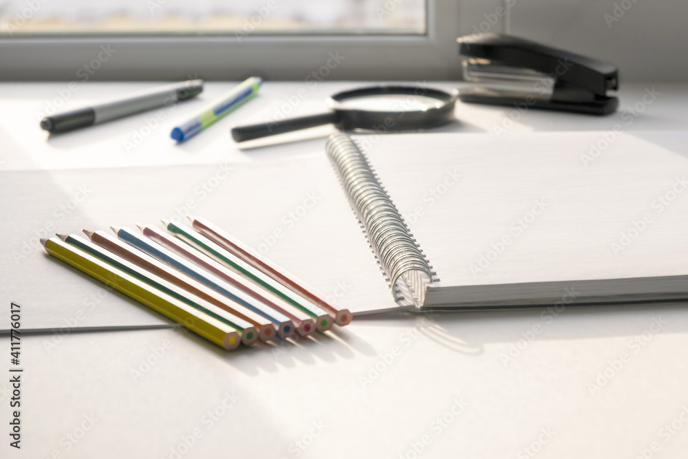 Pencils of different colors lie on an open drawing notebook. Copy space. Pencils of different colors lie on an open drawing notebook. Copy space.