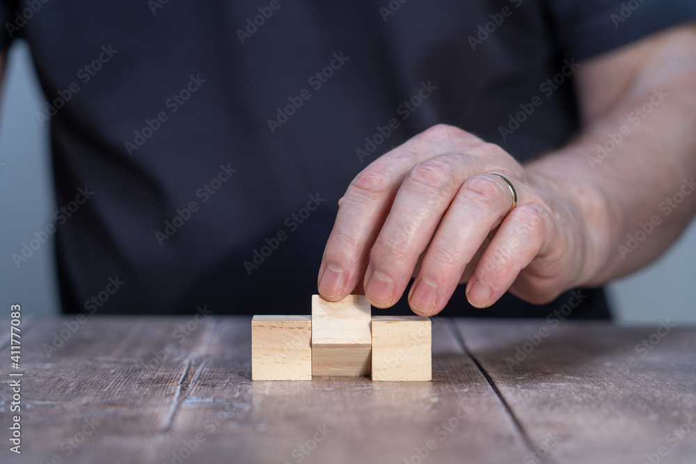 blank template mock up of three timber block cubes , centre one pivoted with a man in the background holding the centre block blank template mock up of three timber block cubes , centre one pivoted with a man in the background holding the centre block