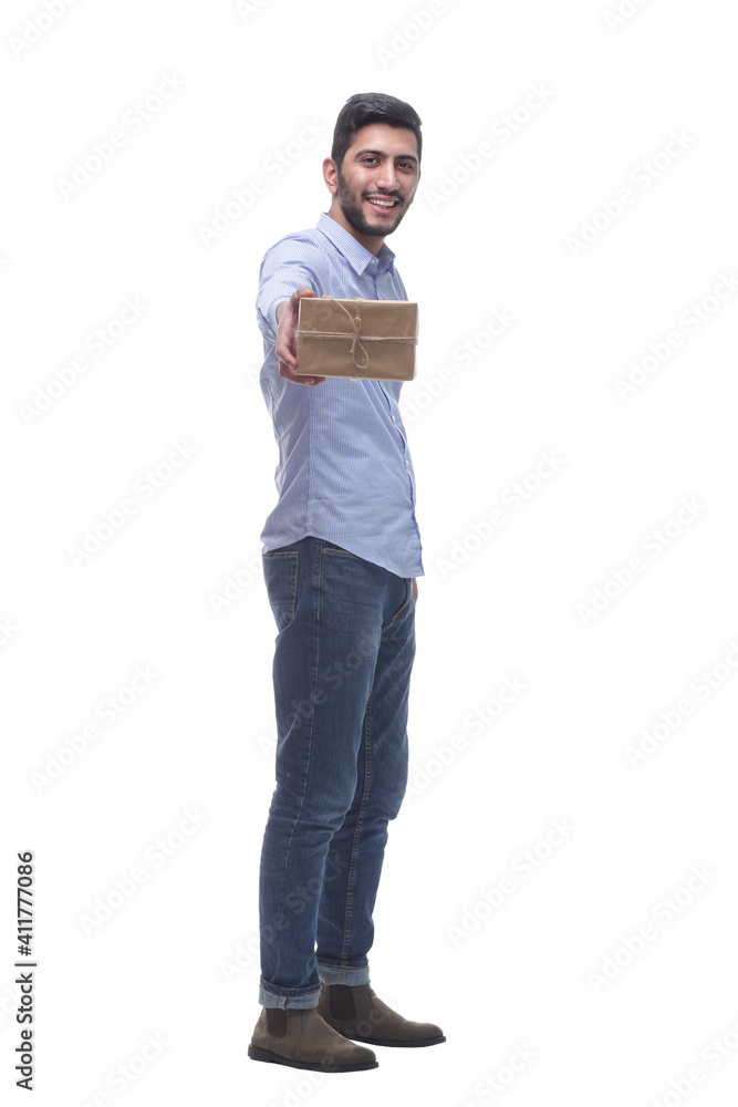 in full growth. happy man handing you a gift box. in full growth. happy man handing you a gift box.