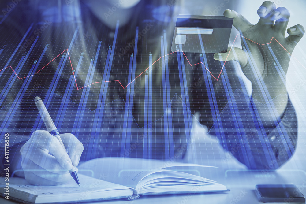 Multi exposure of woman on-line shopping holding a credit card and financial graph drawing. Stock market E-commerce concept. Multi exposure of woman on-line shopping holding a credit card and financial graph drawing. Stock market E-commerce concept.