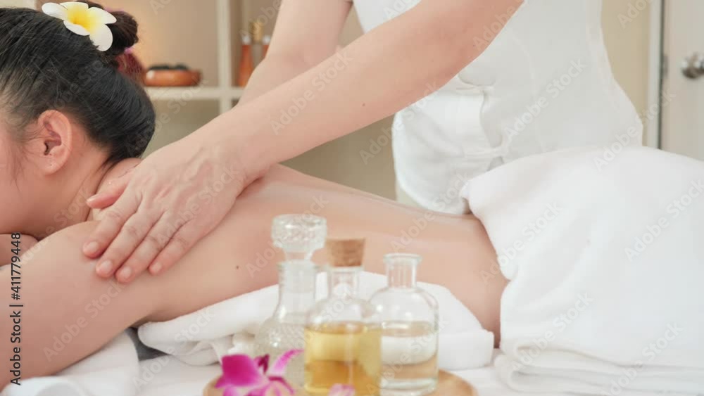 Rear view Young Asian woman getting Relaxing oil massage at beauty spa salon. Body massage, Massage for health. slider shot slow motion Rear view Young Asian woman getting Relaxing oil massage at beauty spa salon. Body massage, Massage for health. slider shot slow motion