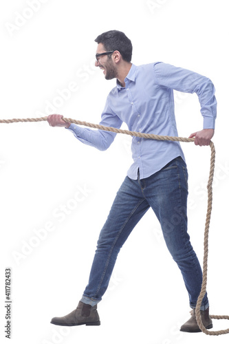 purposeful young man pulls the rope. isolated on a white background.