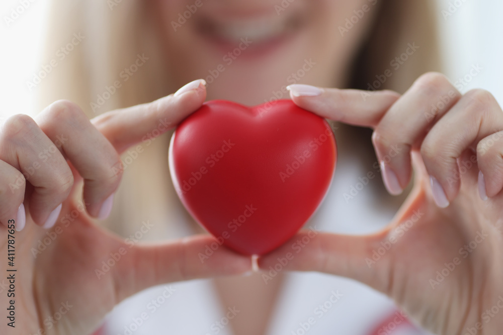 Doctor cardiologist holding red toy heart in his hands closeup Doctor cardiologist holding red toy heart in his hands closeup