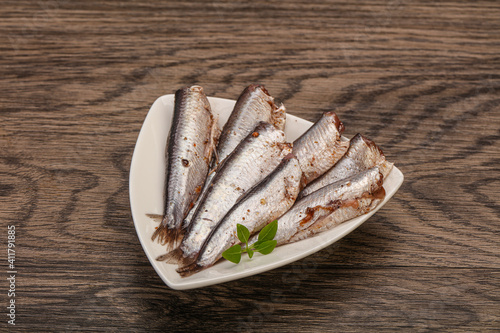 Anchovies in the bowl served basil leaves
