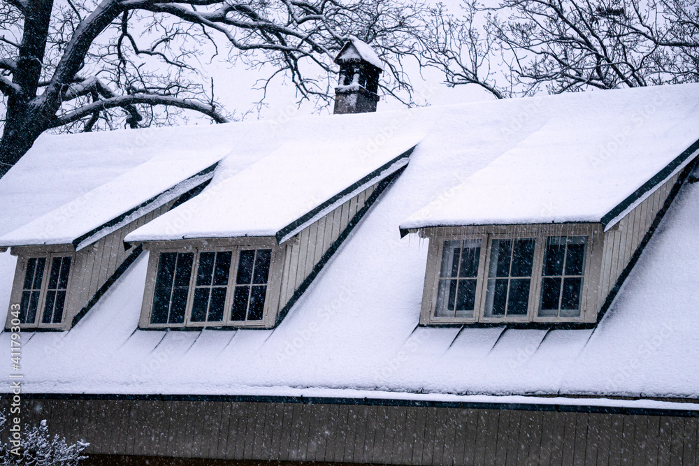 White snow is falling on the roof covered with snow.
